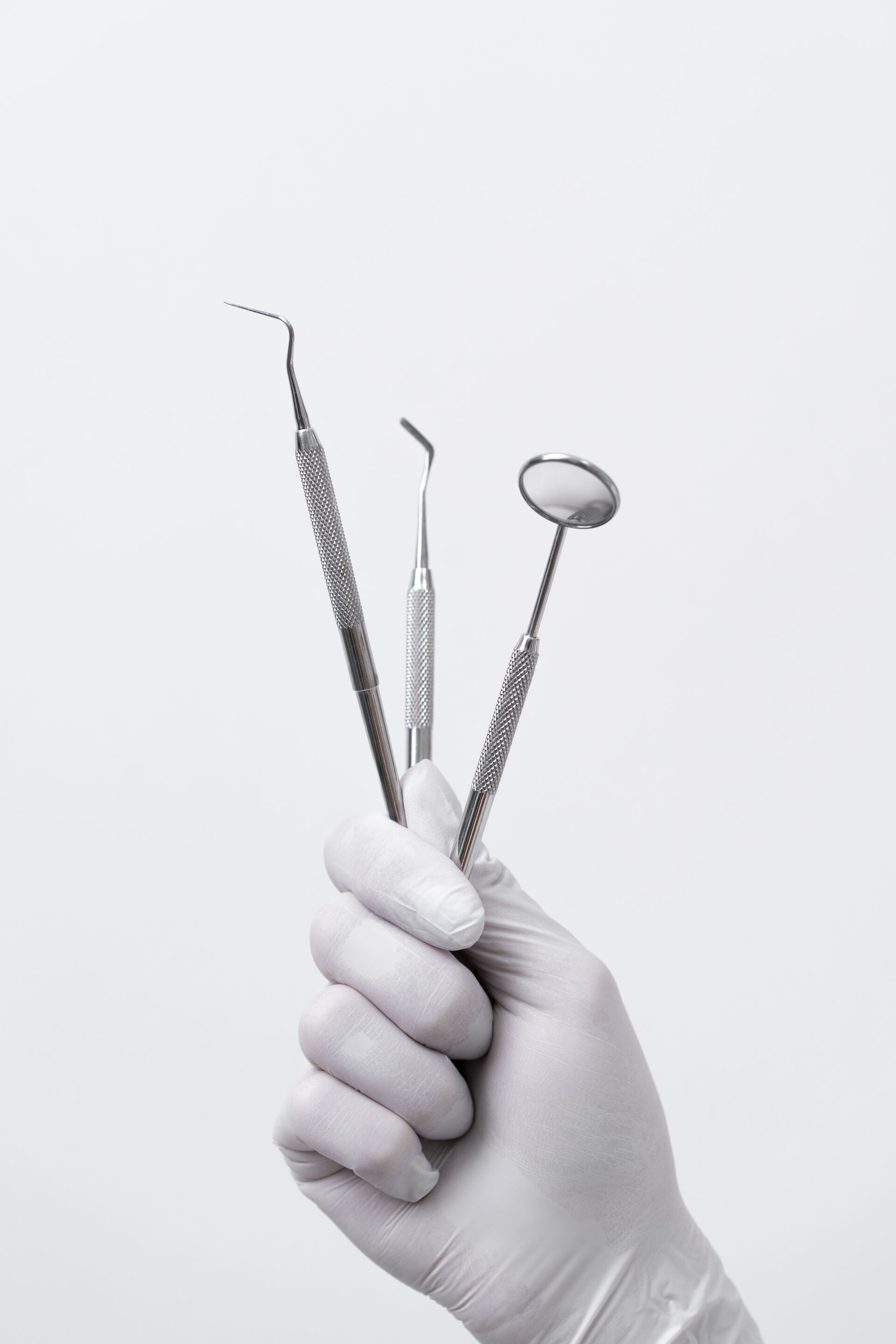 Patient First Dentist holding medical instruments