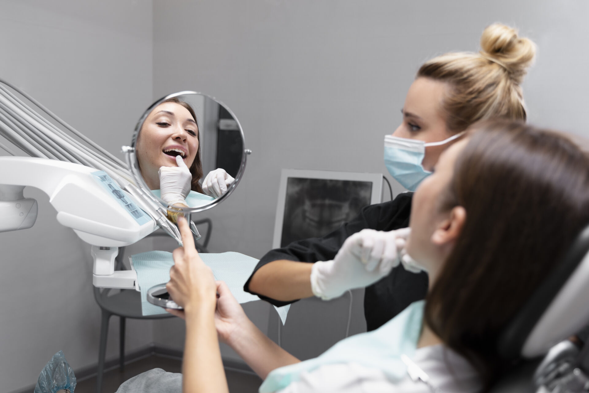 Patient First - Patient looking at their teeth in a mirror