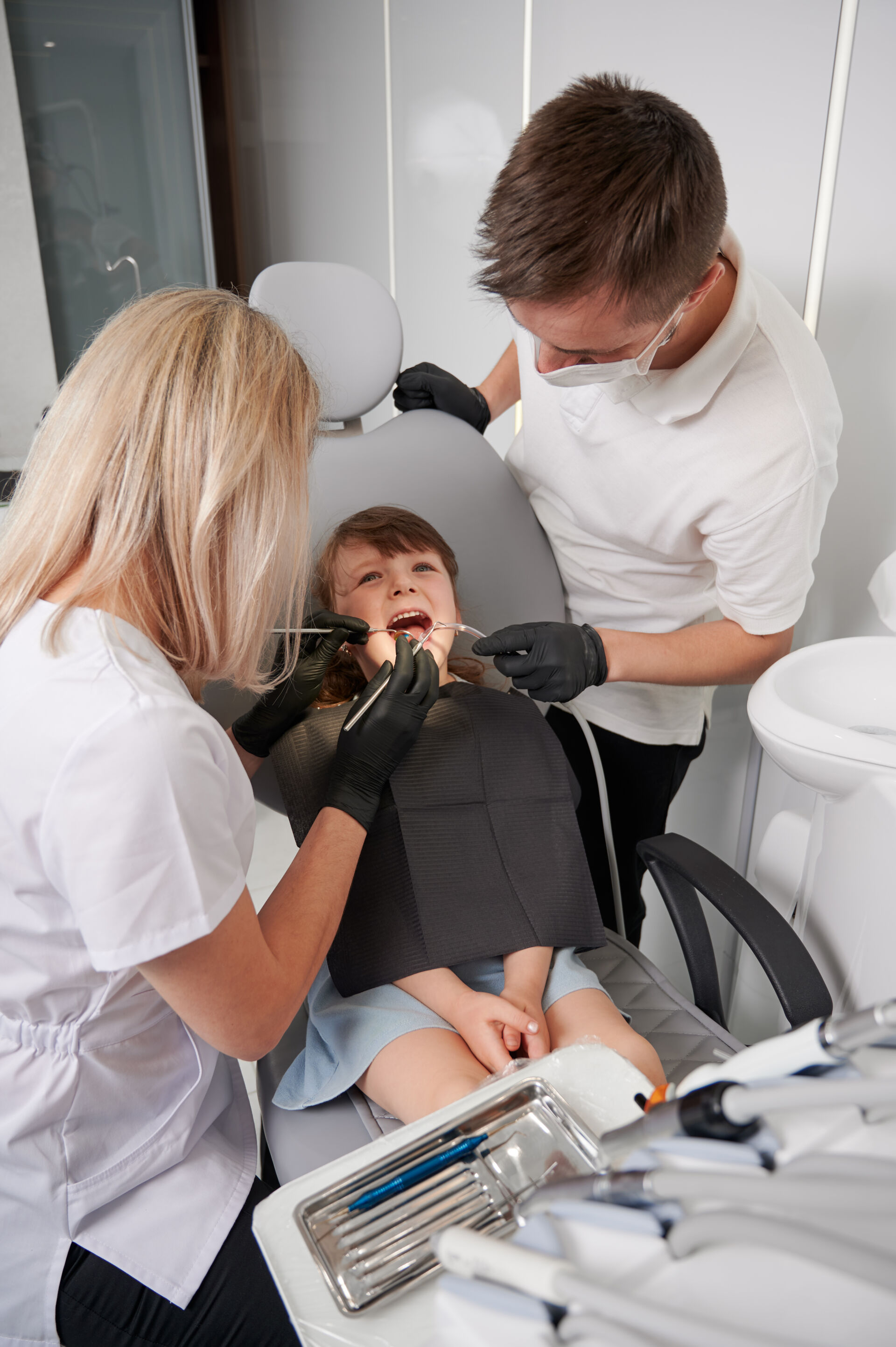Patient First - Dentist and Assistant examining little girls teeth