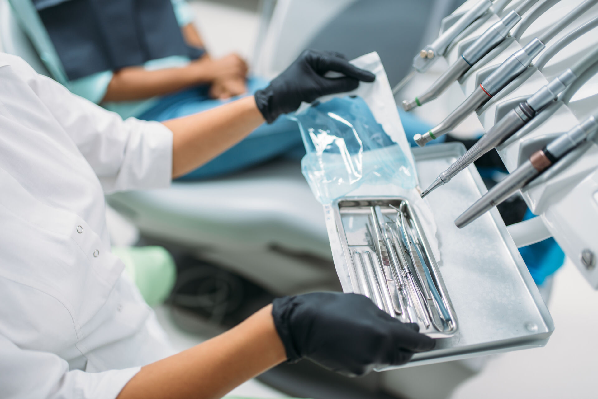 Dentist opening new packet of dental instruments to use for new patient