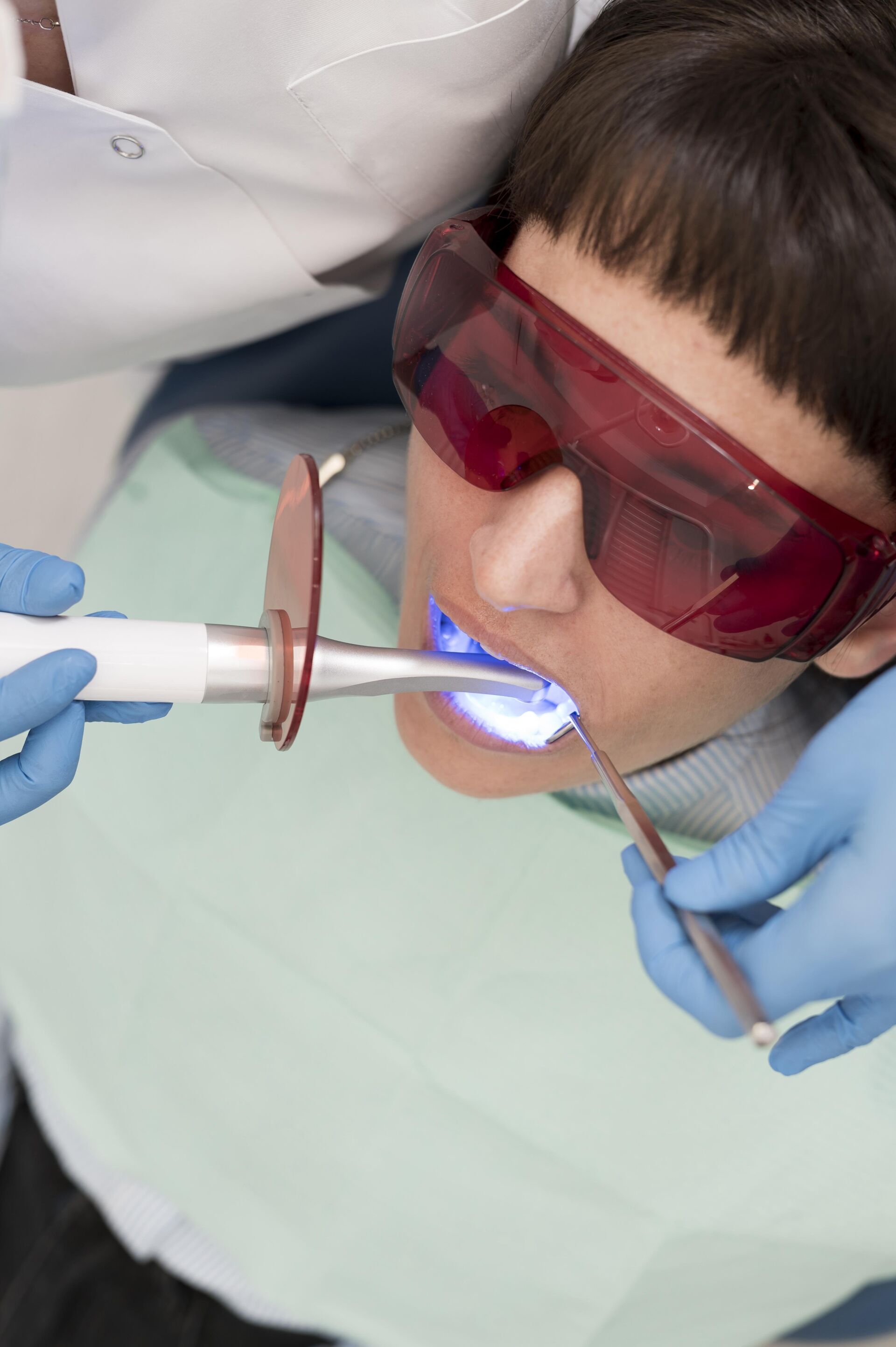 Patient undergoing procedure of Light curing of dental composite by Patient First