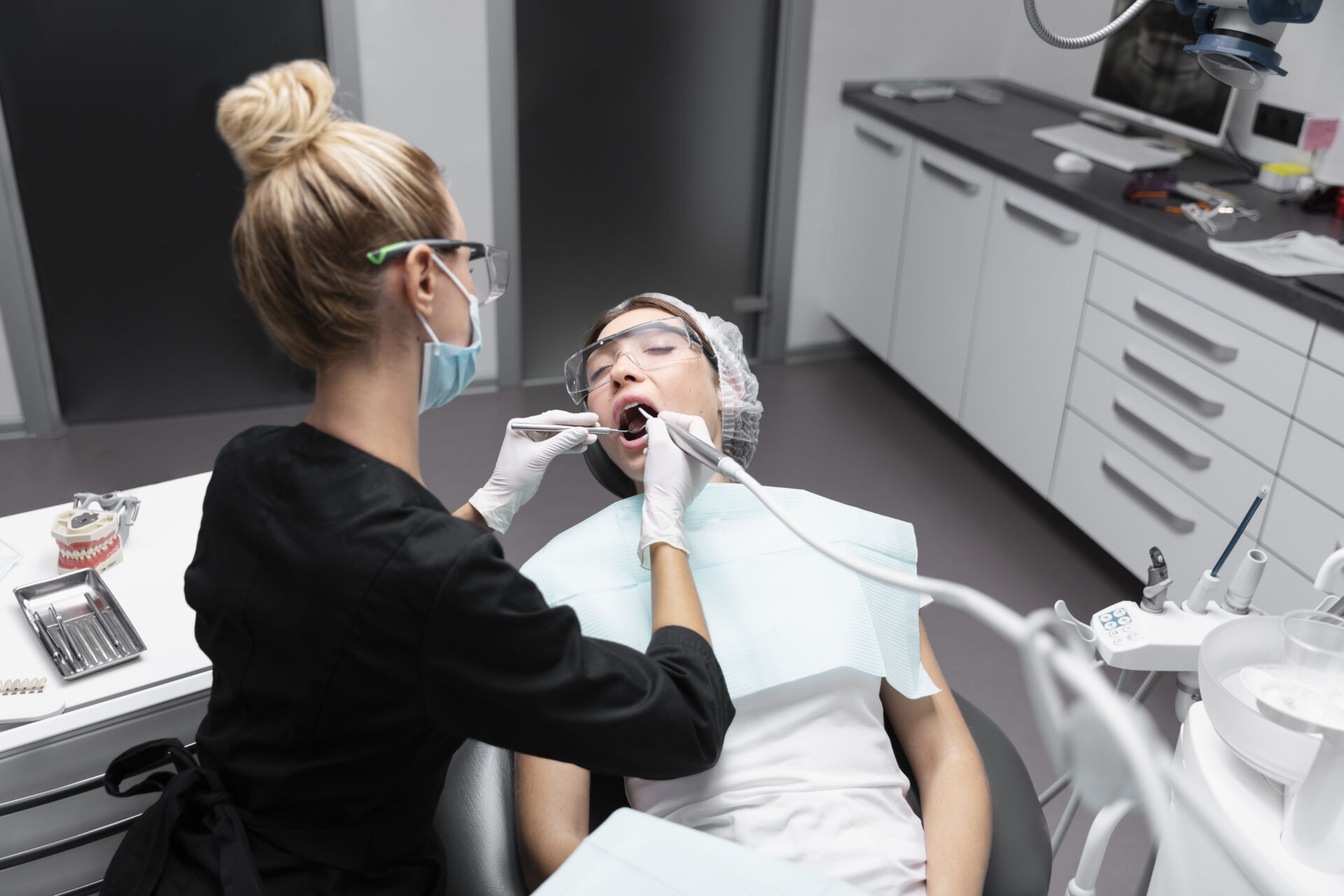 Hygienist from Patient First cleaning patients teeth