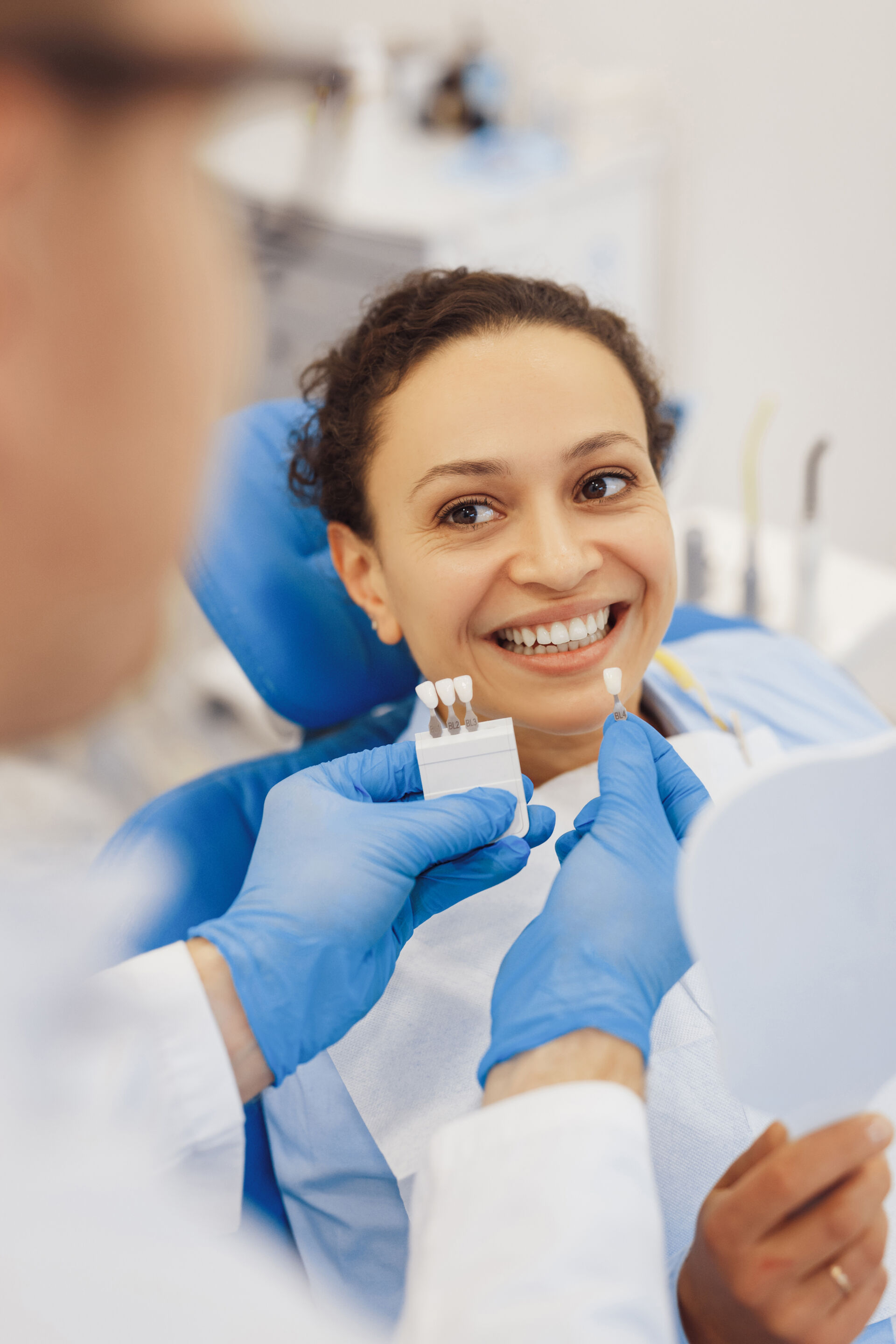 Woman choosing tooth implants color with Patient First Dentist