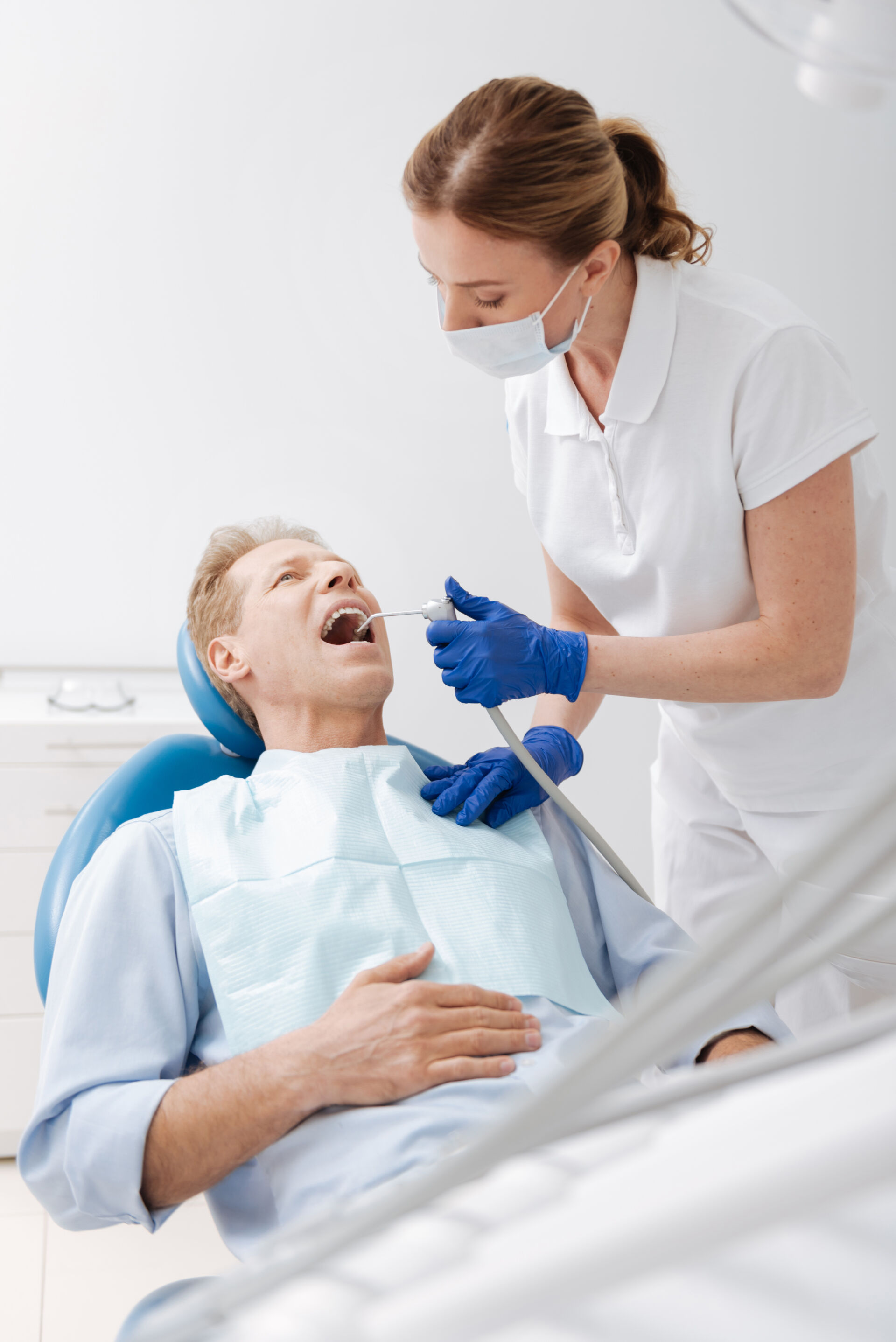 Patient First Dentist cleaning a patients teeth