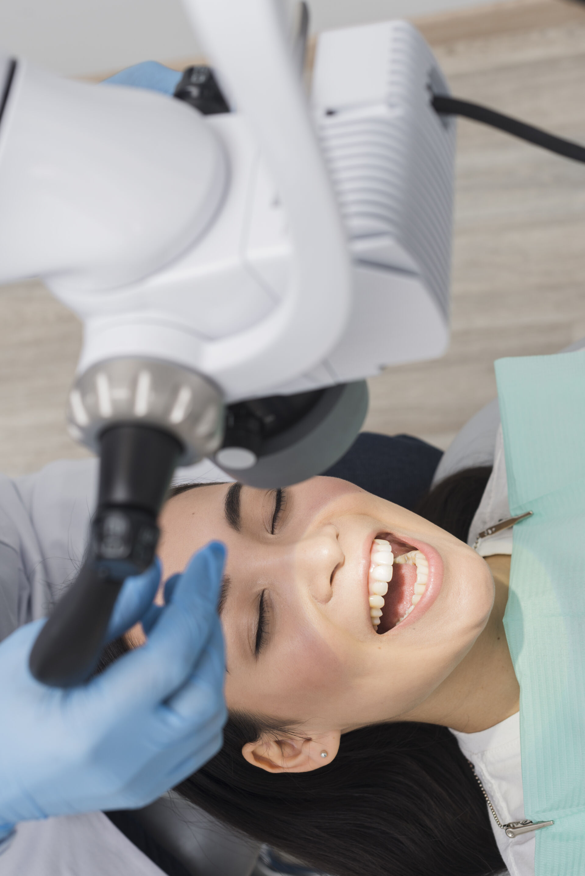 Patient First Dentist adjusting light to see into patients mouth